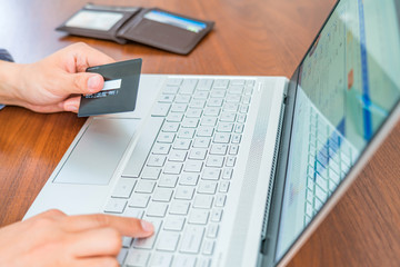 Consumer shopping online with credit card in hand