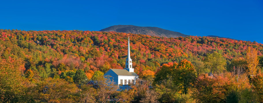 Iconic church in Stowe Vermont middle of fall foliage