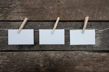 Naklejka na ściany i meble Three white note card pinned to a string on a rustic wooden background