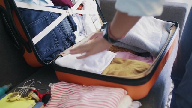 Close up of woman packing bags for holidays, girl preparing suitcase for vacations getting ready for travel