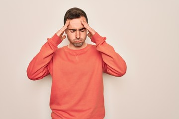 Young handsome man with blue eyes wearing casual sweater standing over white background with hand on head for pain in head because stress. Suffering migraine.