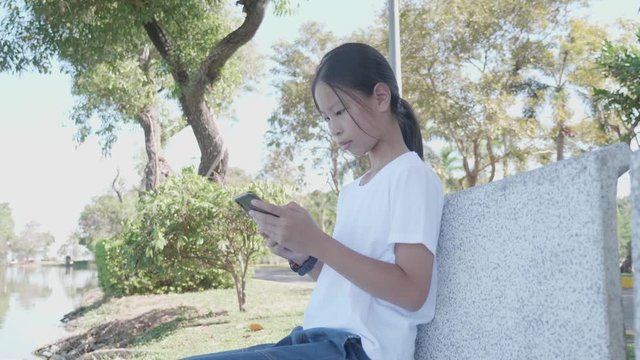 Childhood and technology. Cute asian girl using smart phone. 