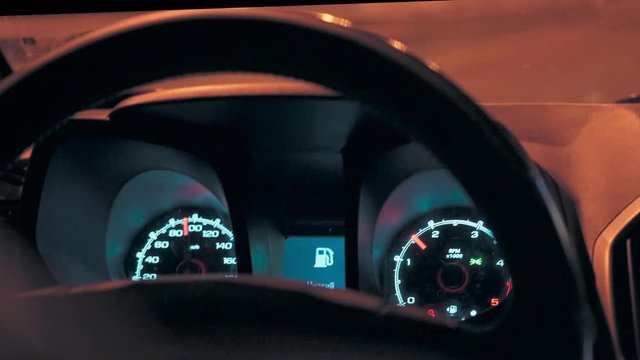 Steering wheel and speedometer in a car while driving at night