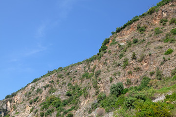 Fototapeta na wymiar green cliff against blue sky