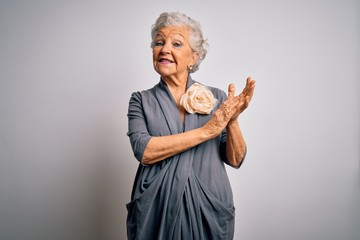 Senior beautiful grey-haired woman wearing casual dress standing over white background clapping and...