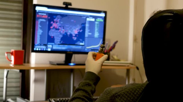 Man with medical gloves, vaping while watching Covid-19 spread on map.