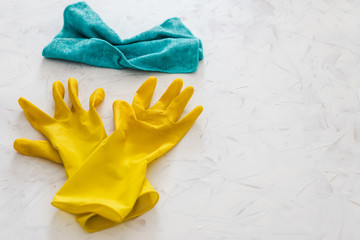 disinfecting and cleaning against bacteria and viruses, yellow cleaning gloves and microfiber cloth on top of surface to be sanitized