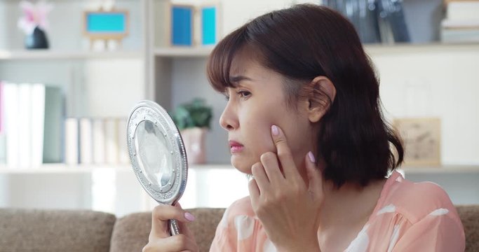 Portrait asian young woman find acne on her cheek