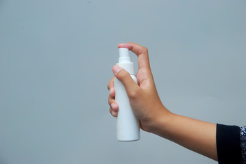 Hand of young Asian woman holding antibacterial spray bottle