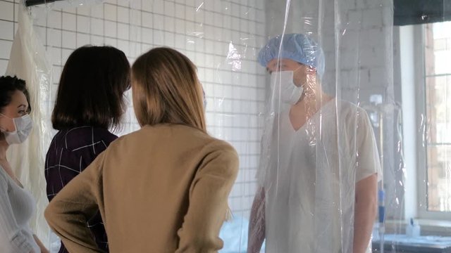 Girls visiting isolated patient in a hospital.
