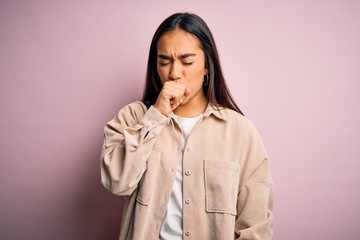 Young beautiful asian woman wearing casual shirt standing over pink background feeling unwell and coughing as symptom for cold or bronchitis. Health care concept.