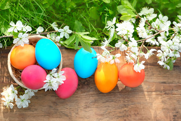 Easter holiday background. colorful Easter eggs and flowering cherry branch in garden
