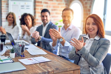 Group of business workers smiling happy and confident. Working together with smile on face looking at the camera applauding at the office