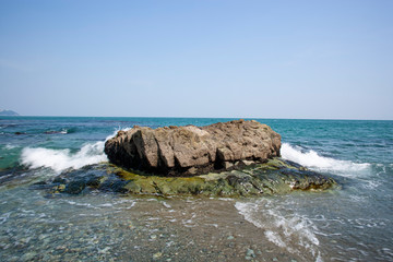 Fototapeta na wymiar 해변가의 바위에 밀려드는 파도