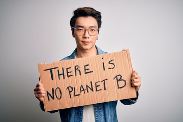 Young handsome chinese activist man protesting asking for care the planet on manifestation with a confident expression on smart face thinking serious