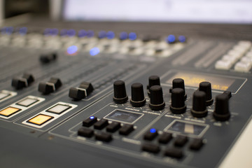 Professional audio mixing console with faders and adjustment knobs.