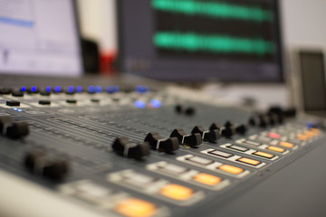 Professional audio mixing console with faders and adjustment knobs.