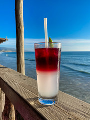 Glass of ice-cooled lemon margarita in front of the sea. Tropical destination