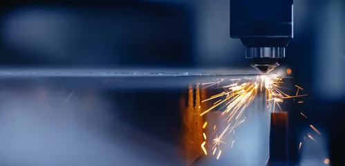 Fototapete Blaue Farbe Laser-CNC-Schnitt aus Metall mit Lichtfunken, moderne Industrietechnologie © Parilov