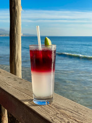 Glass of ice-cooled lemon margarita in front of the sea. Tropical destination