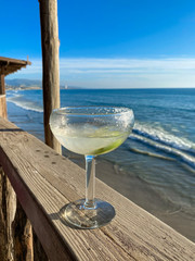 Glass of ice-cooled lemon margarita cocktail in front of the sea. Vacations concept