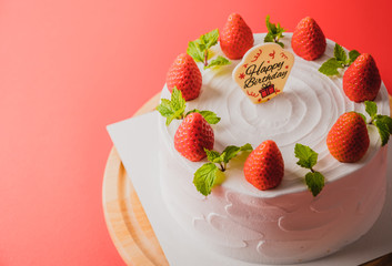  white birthday cake with strawberry decoration on cake, food concept background.