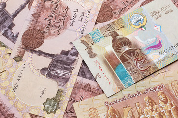 A colorful quarter dinar bank note from Kuwait close up in macro with Egyptian one pound bank notes