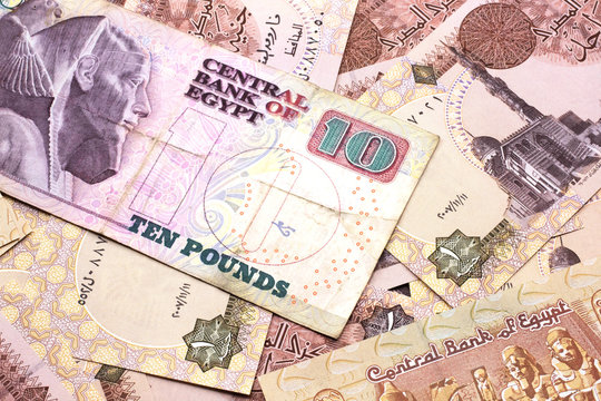 A close up image of an Egyptian ten pound bank note with Egyptian one pound bank notes in macro