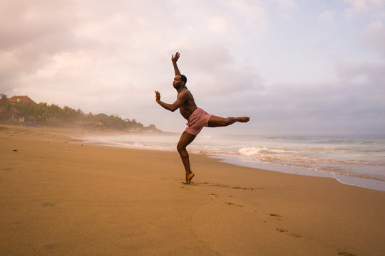 dance choreographer and dancer doing ballet beach workout - young attractive and athletic black African American man dancing outdoors doing beautiful performance