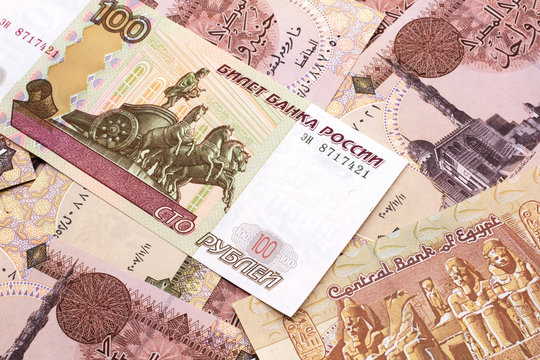 A close up image of a one hundred ruble bank note on a background of  Egyptian pound notes from Mexico.  Shot close up in macro