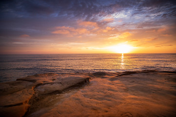 The sky erupts in vibrant colors, as the sun sets over the Pacific Ocean, at Sunset Cliffs in San Diego, California.