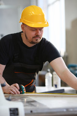 Handsome worker measuring. Manual job DIY inspiration improvement job fix shop yellow helmet joinery startu workplace idea designer career ruler industrial education