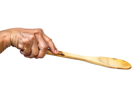 Senior woman's right hand holding wooden ladle on white background, Close up shot, Selective focus, Kitchen utensils concept