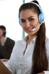 Beautiful brunette smiling call centre clerk at work portrait. Workplace employment effective...