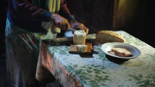 Grandmother in remote village baked terrific bread, rustic pastries, her own bread, cut large slices, bread still hot, steam from cut pieces, rural life in remote villages, elderly woman, specialist
