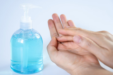 Man washing hands with sanitizer gel bottle or soap for coronavirus prevention, hygiene to stop spreading covid-19 (select focus)