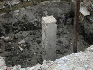 Square precast concrete pile at the construction site. Driven to soil using concrete pile machine. 