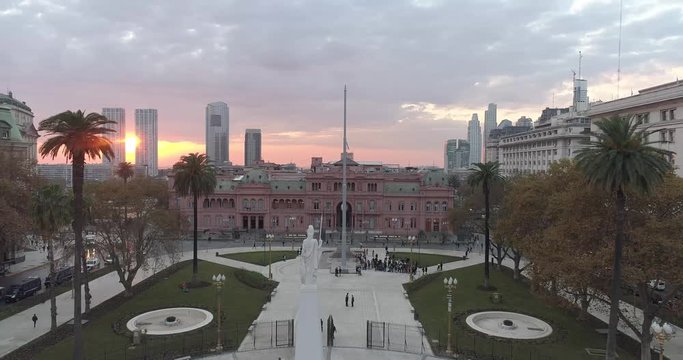 Aerial Drone Scene of May Square and Casa Rosada. The camera travels forward with a flaming flag. Landscape of the pyramid and pink house, historic building. Buenos Aires, Argentina