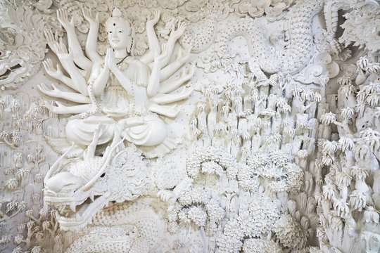 white gaunyim and dragon sculpture on wall of huai pla kang temple in chiang rai