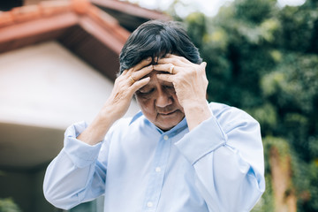 Portrait of an elderly man with headache.senior man covering his face with his hands.vintage tone