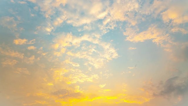 Time lapse cloudscape of wind blowing beautiful white fluffy clouds in clear blue sky with sun shining golden rays passing through the cloud at sunrise. Heaven, dream, inspiration and freedom concept