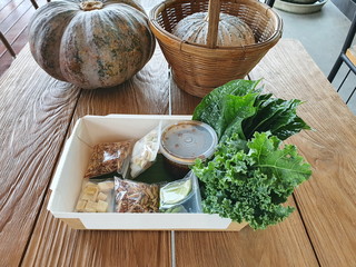 Miang Kham Vegetarian: Spicy wrapped leaves are Thai food that consists of herbs such as onions, ginger, lemon, fresh chilies, roasted coconut wrapped in kale leaves and spicy wrap topped with sauce. 