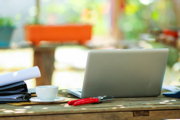 Laptop on wood table for working online at home in the garden.
