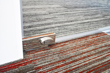 Close up of glass door lock, Floor stainless steel door lock , concept image for security at modern office  building and door fitting equipment  concept.