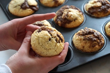 Cake with melted chocolate in the girl hand, close up