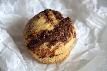 Cookie on the baking paper. Tasty cookie with melted chocolate close up view