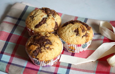 Homemade muffins. Three fresh baked muffins on a crochet patterned kitchen cloth