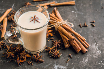 Tasty tea mith milk and spices on the rustic background. Selective focus. Shallow depth of field.