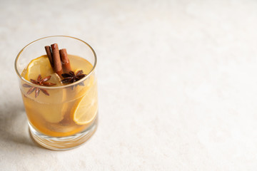 Healthy hot beverage with lemon, ginger and spices for protection in flu season. Selective focus. Shallow depth of field.