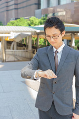 Middle aged boss is looking on his watch. 